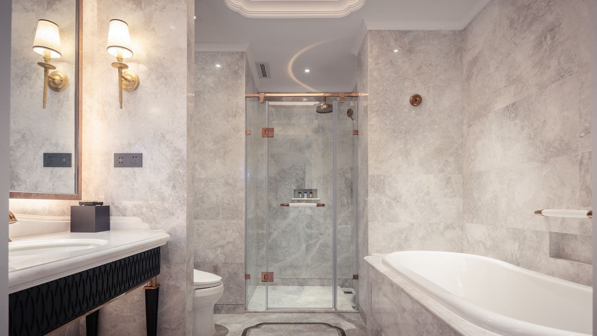 Baño de mármol con ducha de cristal